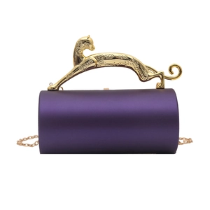 Close-up of golden leopard handle and purple velvet texture on cylindrical evening bag