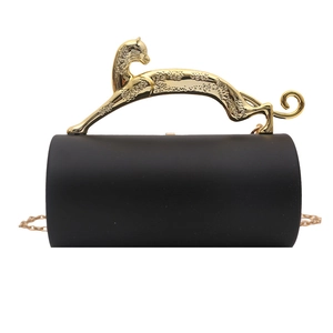 Close-up of black matte cylindrical clutch with a golden leopard metal handle and chain