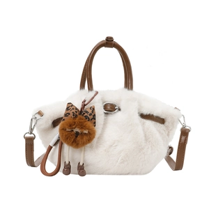 Detail of white faux fur handbag with brown leather handles and adjustable shoulder strap