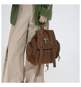 Detailansicht eines braunen Wildleder-Gothic-Rucksacks mit silbernen Nieten und Kreuzanhänger