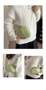 Macro detail of a light green pebble-shaped clutch bag with golden chain and clasp