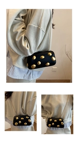 Chic black evening bag with gold rivets and chain strap shown on a model