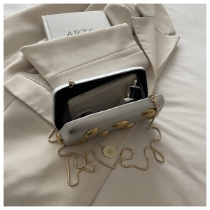 Silver mirror evening clutch interior showing capacity for phone and perfume accessories