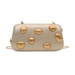 Detail of champagne gold evening bag with metallic oval textures and a slim chain strap