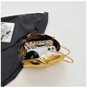 Detail view showing golden acrylic clutch interior with phone and cosmetics