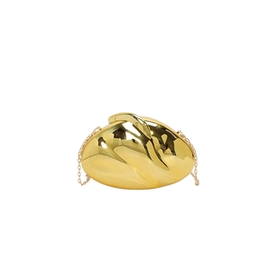 Detail of a luxury gold fluid-shaped evening bag with a polished mirror finish and chain