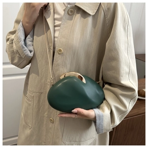 Detail of dark green pebble box clutch with gold crescent clasp and chain strap