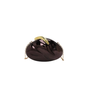 Detail of a dark brown acrylic evening clutch with gold hardware and chain strap