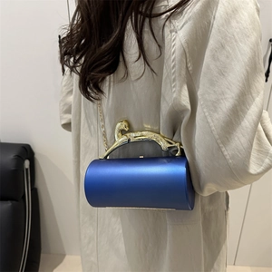 Blue satin cylindrical clutch bag featuring a gold leopard handle and chain strap