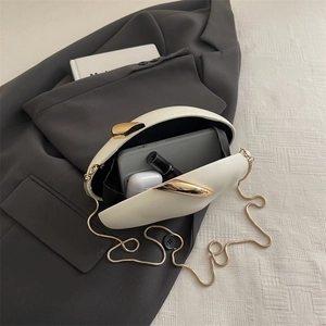 Interior view of the cream PU box bag showing storage for phone and lipstick