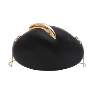 Detail of black pebble-shaped clutch bag featuring a gold horn-style buckle and chain