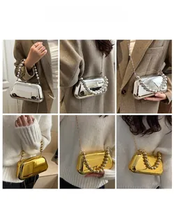 Detail of metallic acrylic evening bag with pearl handle and chain strap