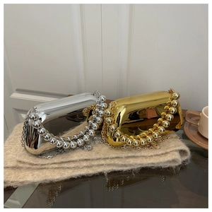 Detail of metallic acrylic clutch bag with large bead handle and fine chain strap