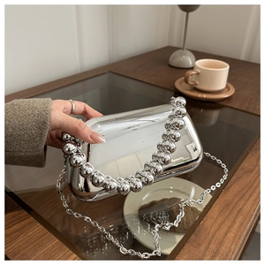 Close-up of silver electroplated evening clutch with oversized bead handle and chain strap