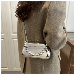 Close-up of a silver acrylic evening bag with a metallic bead handle and chain strap