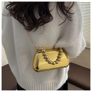Close-up of gold electroplated evening box bag with metallic beaded handle and chain