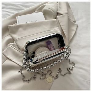 Interior view of silver evening bag showing storage space for phone and makeup
