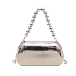 Detail of silver metallic mirror clutch bag featuring a beaded handle and fine chain strap