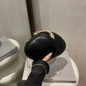 Elegant black pebble-shaped dinner clutch bag with gold chain and minimalist metal clasp