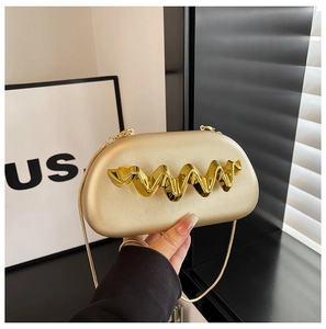 Detail of champagne gold evening clutch with wavy gold metal trim and snake chain