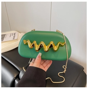 Detail of green semi-circle evening clutch with gold wave metal decor and snake chain