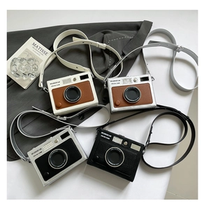 Macro shot of camera-shaped crossbody bags in four colors with lychee texture detail