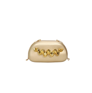 Detail view of gold evening clutch bag with wave metal pattern and chain strap