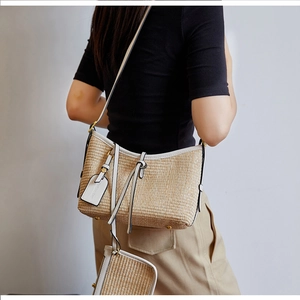 Detail of woven straw tote bag with white leather trim and a matching small coin purse