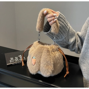 Close-up of plush bucket bag texture with carrot embroidery and soft bunny ears