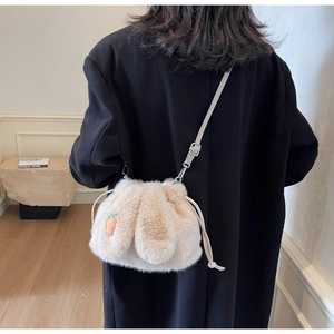 Detail of plush bunny ear bucket bag with carrot embroidery and drawstring closure