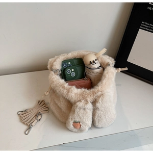 Detail of plush strawberry bucket bag showing capacity for phone, wallet and umbrella