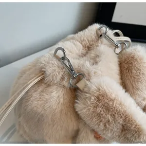 Detail shot of beige plush bucket bag showing fluffy faux fur texture and drawstring top