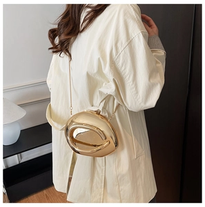 Macro view of gold-tone irregular hollow bean-shaped clutch bag with metal chain