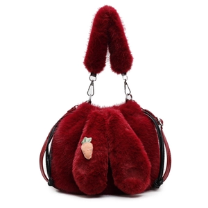 Detailed close-up of plush bucket bag with fuzzy rabbit ears and carrot embroidery