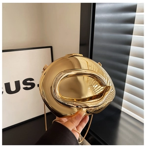 Macro detail of glossy gold organic bean shaped evening bag with thin metal chain