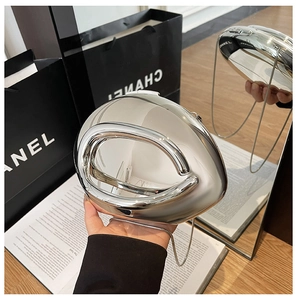 Silver liquid metal evening clutch bag with hollow handle and chain shown in hand