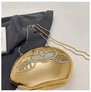 Detail of gold mirror evening clutch with rhinestone floral pattern and snake chain