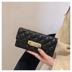 Detalle de cartera larga de cuero negro acolchado con cierre rectangular de metal dorado