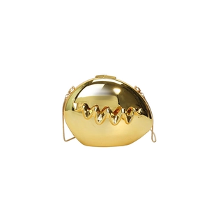 Detail of gold evening clutch bag with metallic wavy texture and slim chain strap