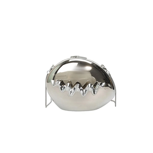 Detail of silver egg-shaped evening clutch with mirrored surface and metallic chain strap