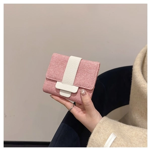 Close-up of pink woven short wallet with white faux leather clasp held by hand