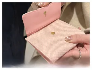 Close-up of pink woven wallet showing high-quality snap closure and interior detail
