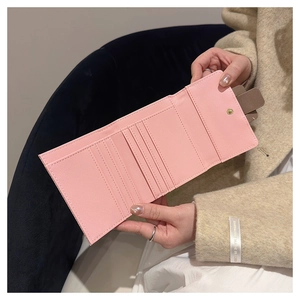 Interior detail of pink cross-grain leather wallet with multiple card slots and snap button