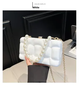 Detailed view of white acrylic evening bag with 3D wave texture and faux pearl handle