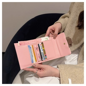 Detail of pink faux leather trifold wallet with multiple card slots and cash pocket