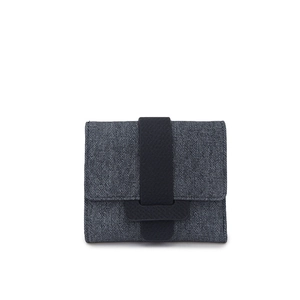 Detail view of charcoal gray denim texture on a compact trifold wallet with black buckle
