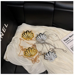 Detailed view of mini metallic shell bags in gold and silver finish with chain straps