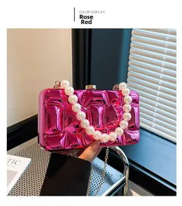 Detail of rose red acrylic evening bag featuring wavy texture and pearl top handle