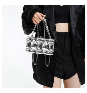 Detail of silver metallic hard case bag with 3D quilted texture and ball chain handle