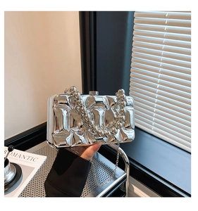 Detail of silver wavy acrylic evening clutch with beaded handle and metal chain